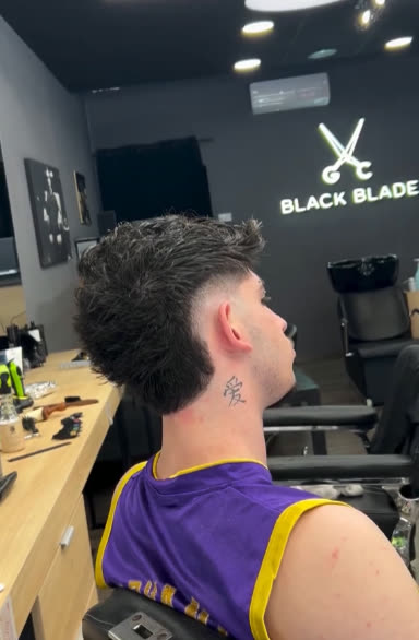 Black Blade SKG neon sign above the barber chairs